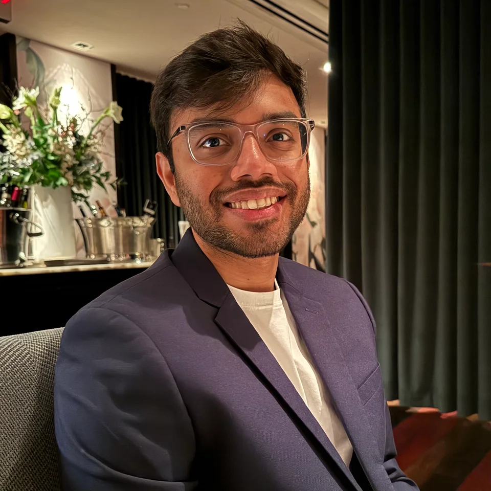Sparsh Paliwal smiling, wearing glasses and a blazer